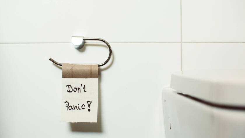 Note on toilet paper roll with a message saying "Don't Panic!" in a modern bathroom setting, emphasizing comfort and humor in smart toilet experiences.
