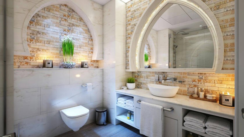 Modern bathroom featuring a smart toilet, elegant arched mirror, stylish stone wall, and contemporary fixtures, showcasing a luxurious upgrade for enhanced comfort and hygiene.